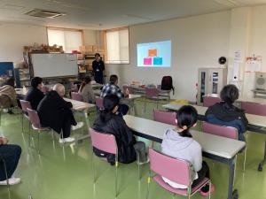 スライドを用いて説明している写真