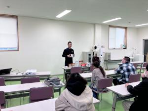 スライドを用いて説明している写真